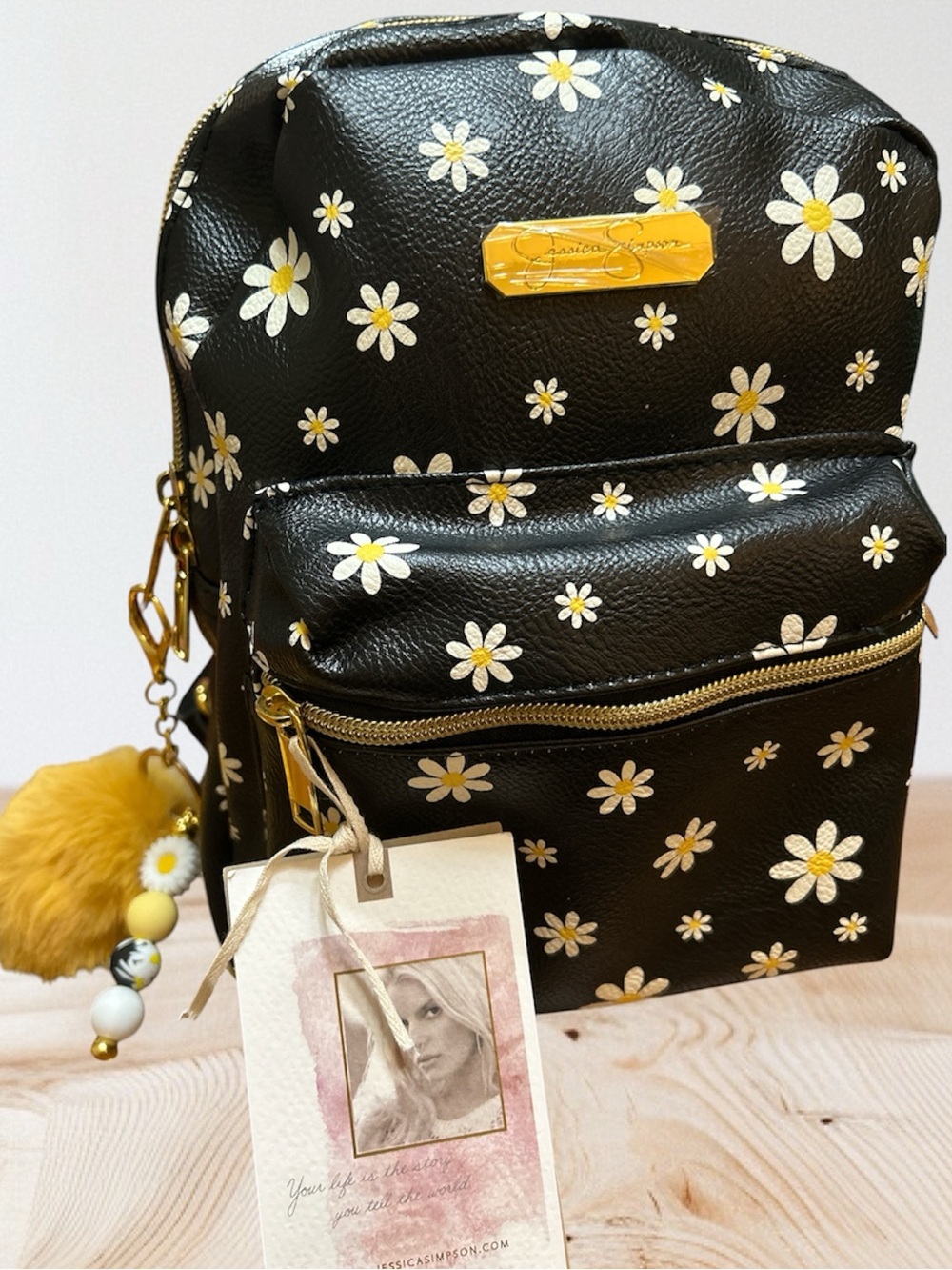 Jessica Simpson Black Daisy Mini Backpack with Gold Hardware and 2 Charms.  
NWT